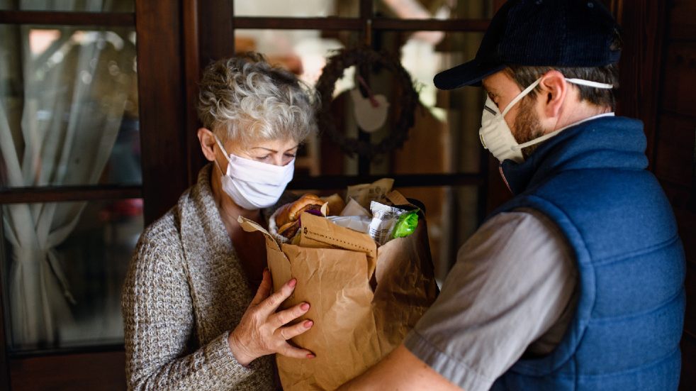 Help your community recover from the pandemic woman taking food delivery